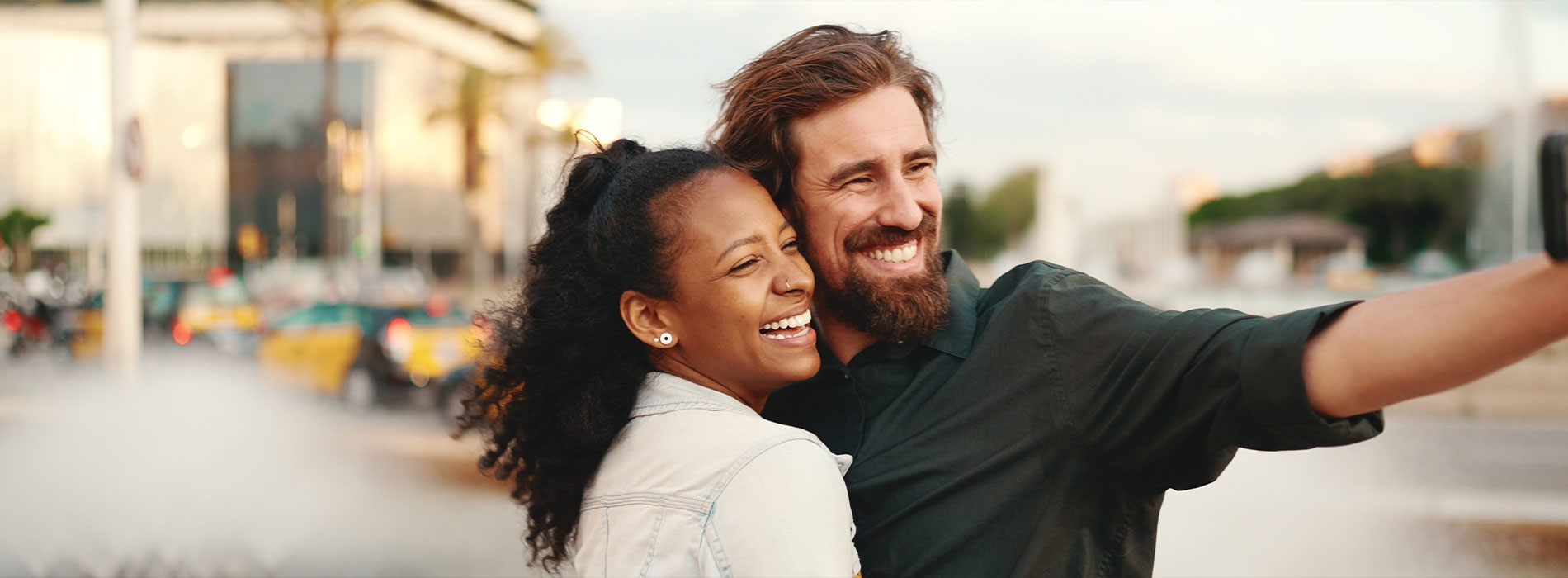 The image is a photograph of a woman with light skin, smiling at the camera. She appears to be in her late twenties or early thirties and has long hair. Her eyes are looking directly at the camera, and she is holding up her index finger near her mouth as if she s making a point or emphasizing something. The background is plain and light-colored, which suggests that this could be a stock photo used for various purposes such as advertising, personal branding, or lifestyle content.