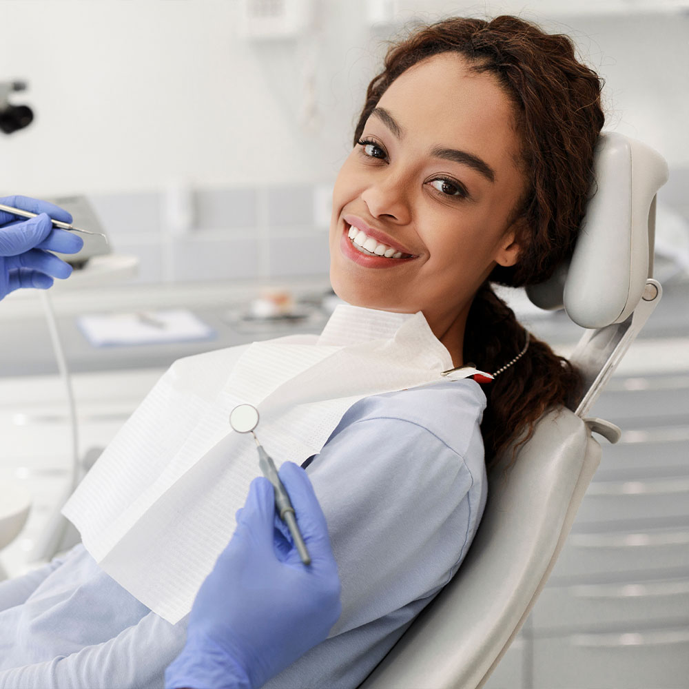 A dental professional is assisting a patient with a digital display of the patient s mouth, highlighting dental work in progress.