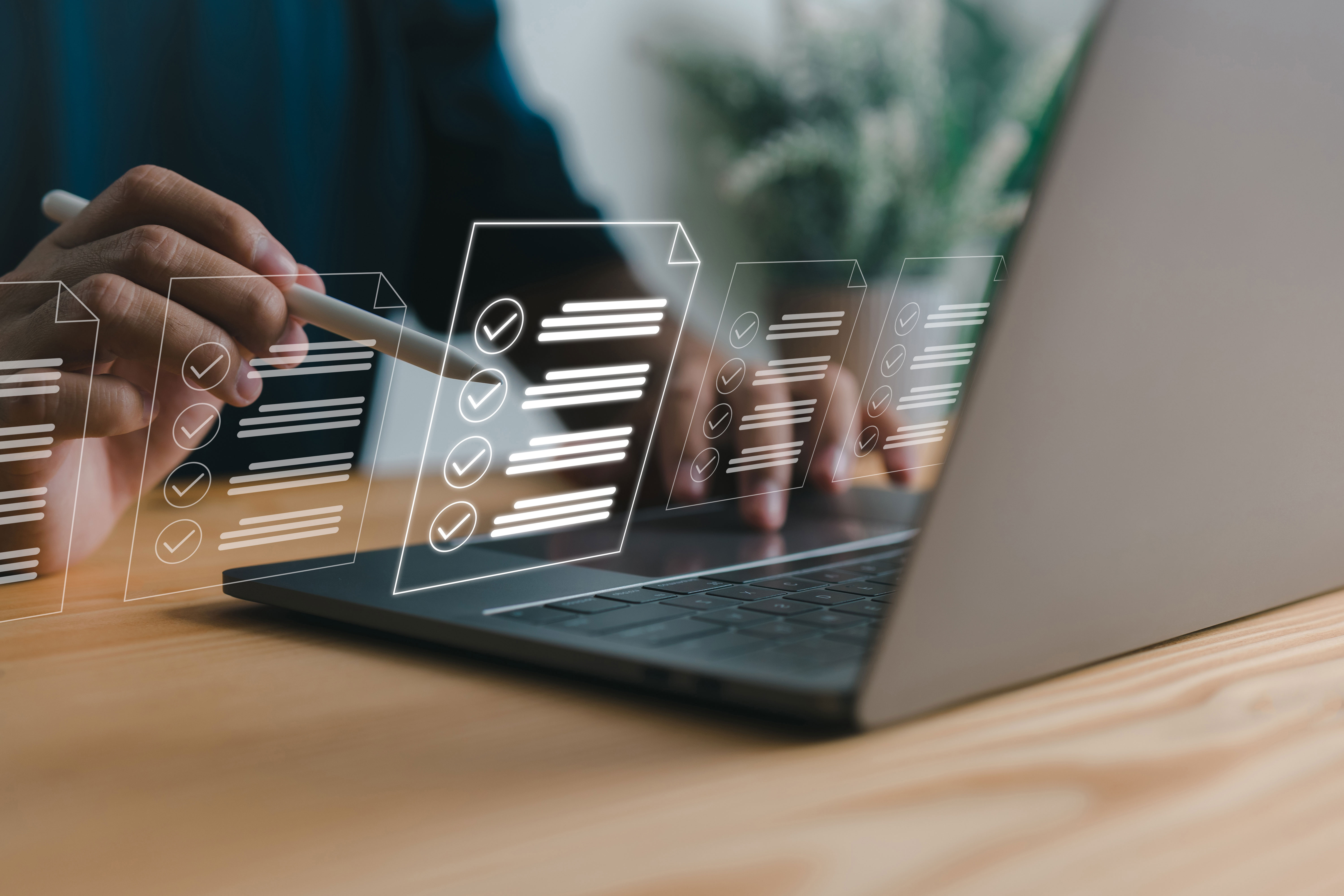 A person's hands holding a laptop with a digital interface displaying checkboxes and text, suggesting interaction with software or data management.