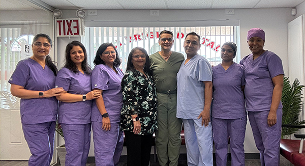 The image shows a group of healthcare professionals posing together in front of a building with a sign that reads Texas Health Resources.